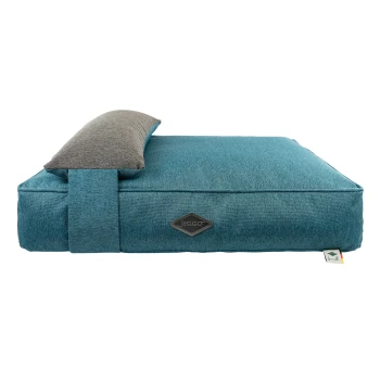 Hundekissen Grenoble petrol S Ein türkisfarbenes Haustierbett mit einer grauen gepolsterten Kopfstütze, mit einem Jeggo-Logo an der Seite und einem Etikett in der Ecke.