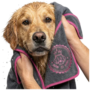Ein gerolltes dunkelgraues Haustierhandtuch mit einem rosa Rand, mit einem runden Logo eines Hundes, der eine Krone trägt, und dem Text "HUND IST KÖNIG."