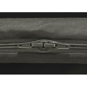 Nahaufnahme eines schwarzen Doppelreißverschlusses auf strukturiertem Stoff, wahrscheinlich Teil einer Tiertransporttasche oder -tasche.