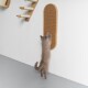 Eine hellgraue Katze streckt sich, um ein an der Wand montiertes Kratzbrett in einem modernen Tiergeschäft zu kratzen.