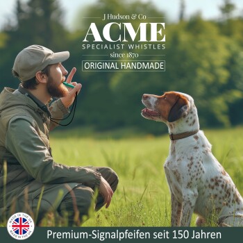 Mann in Outdoor-Ausrüstung benutzt eine ACME Spezialpfeife, um einen sitzenden Hund auf einer Wiese zu trainieren, Text "Original Handmade" sichtbar.