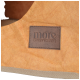 Gros plan sur un lit pour animal beige avec un patch en cuir marron portant l'inscription « more LIFESTYLEPETS ».