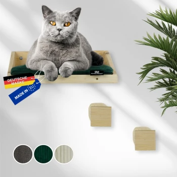 Graue Katze mit orangen Augen, ruhend auf einem hölzernen Wandregal mit grünem Kissen, Etiketten mit der Aufschrift „Deutsche Marke“ und „Made in EU“.