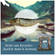 Getrockneter Fisch, der prominent mit einem verschwommenen natürlichen Hintergrund präsentiert wird; der Text lautet "Direkt vom Hersteller - Qualität made in Germany."