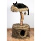 Eine schwarze Katze, die auf einem plüschigen, mit Fell gefütterten Katzenbaum mit einem Holzpfosten und einem gemütlichen Versteck an der Basis liegt.