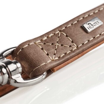 Nahaufnahme einer braunen Leder-Hundeleine mit dekorativer Naht und einem silbernen Metallclip, die ein kleines "HUNTER"-Logo zeigt.