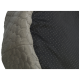 Nahaufnahme eines Haustierbettes mit einem hexagonalen, strukturierten grauen Stoff auf einer Seite und einem glatten schwarzen Stoff mit kleinen Punkten auf der anderen.