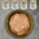 Dosenfutter für Haustiere mit glatter, rosa Fleischtextur und Etiketten für getreidefrei, hoher Proteingehalt, ohne Zuckerzusatz und Vitamine A, E und D3.