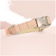 Ein weiches rosa und beiges Haustierhalsband mit einer Metallschnalle und D-Ring, gegen einen hellrosa Hintergrund präsentiert.