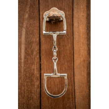 Ein glänzender silberner Türklopfer in Form eines Pferdegebisses, montiert an einer Holztür.