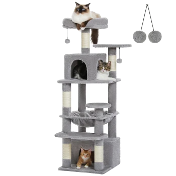 Ein mehrstöckiger grauer Katzenbaum mit einer flauschigen weißen Katze oben, einer getigerten Katze in einer Nische und einer orangefarbenen Katze darunter, mit zwei hängenden Pompons.