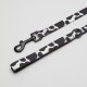 Eine stilvolle Hundeleine mit einem schwarz-weißen Kuhflecken-Design, mit einem stabilen schwarzen Clip zur Befestigung.