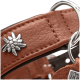 Nahaufnahme eines braunen Lederhalsbands mit silbernem Blumen‑Niet, Metall‑D‑Ringen und Anhänger mit teilweise sichtbarem Text 'HU'.