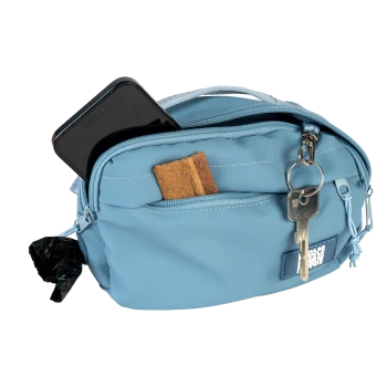 Hellblaue Leckerli-Tasche für Haustiere mit Telefon, Hundekeksen, Schlüsseln und angebrachtem schwarzem Kotbeutelspender.
