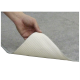 Eine Hand, die eine Ecke einer grauen Tiermatte anhebt und eine strukturierte weiße Unterseite zeigt.