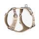 Beige Hundegeschirr mit einem gemusterten Riemen, mit verstellbaren Clips und einem metallenen D-Ring zur Leinenbefestigung.