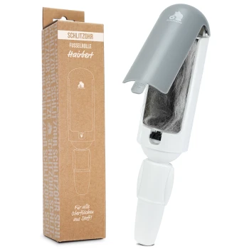 Eine Fusselrolle mit grauem Deckel und weißem Griff, neben ihrer braunen Kartonverpackung mit der Aufschrift "Schlitzohr Fusselrolle Hairbert" für Stoffoberflächen.