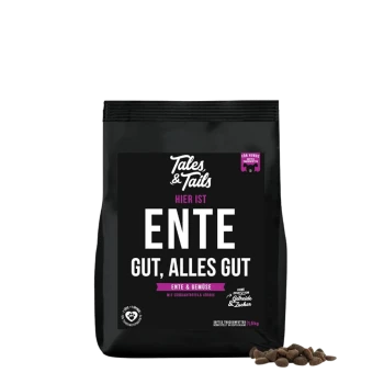 Schwarze Tales & Tails Hundefuttertüte mit der Aufschrift ‚HIER IST ENTE GUT, ALLES GUT‘ und einem kleinen Haufen Trockenfutter.