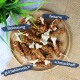 Ein Holzbrett mit hundeknochenförmigen Leckerlis, beschriftet auf Deutsch: "Belohnung", "fettarm", "gut bekömmlich" und "schmackhaft."