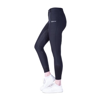 Schwarze Reitleggings mit einem Logo, die ein gepunktetes Design an einem Bein und eine enge Passform aufweisen, kombiniert mit weißen Sneakers.