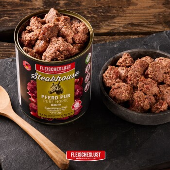 Geöffnete Dose FLEISCHESLUST Steakhouse 'PFERD PUR' Nassfutter, Stücke in der Dose und in einer Schüssel mit Holzlöffel.