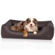 Ein glücklicher Australian Shepherd, der in einem stilvollen braunen Haustierbett mit einem Logotag entspannt und Komfort und Entspannung zeigt.