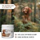 Ein brauner Hund steht in einem Wald neben einem weißen Behälter mit der Aufschrift "REAVET ULMENRINDE PLUS", mit dem Hinweis "100% Naturprodukt" und "Hergestellt in Deutschland."