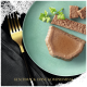 Ein grüner Teller mit Haustierfutter-Pâté mit Petersilie, ein Riegel des gleichen Futters und eine goldene Gabel. Der Text darunter sagt "GESCHMACK OHNE KOMPROMISSE."