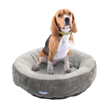 Ein Beagle sitzt bequem in einem runden, plüschigen Hundebett mit grauer und beiger Farbgestaltung, das ein Logo an der Seite hat.