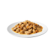 Une assiette de morceaux de viande hachée humide dans une sauce avec de petits morceaux de carottes orange, mettant en avant une option de nourriture pour animaux copieuse.