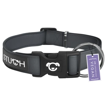 Ein graues Hundehalsband mit einer schwarzen Schnalle, das ein Hundelogo und das Wort "STUCH" zeigt. Es hat ein Etikett, das "PETA APPROVED VEGAN" liest.