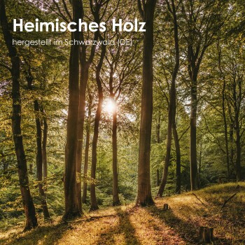 Sonnenlicht filtert durch einen üppigen Wald aus hohen Bäumen, mit dem Text "Heimisches Holz" und "hergestellt im Schwarzwald (DE)" deutlich angezeigt.