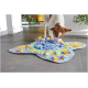 Chien brun et blanc reniflant un tapis de fouille jouet violet, bleu sarcelle et jaune sur un sol carrelé