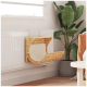 Ein gemütliches, gewebtes Haustierbett, das an einem weißen Heizkörper befestigt ist, mit einem weichen Kissen und einer grünen Pflanze im Hintergrund.
