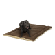 Ein schwarzer Labrador Retriever liegt auf einem großen, plüschigen braunen Hundebett mit beigem Rand und sieht zufrieden mit herausgestreckter Zunge aus.