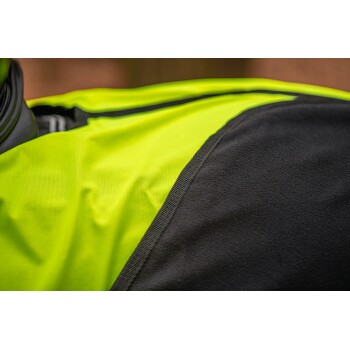 Nahaufnahme einer Haustierjacke mit einem hellgelben Stoff auf einer Seite und schwarzem Fleece auf der anderen, die ihr zweifarbige Design zeigt.