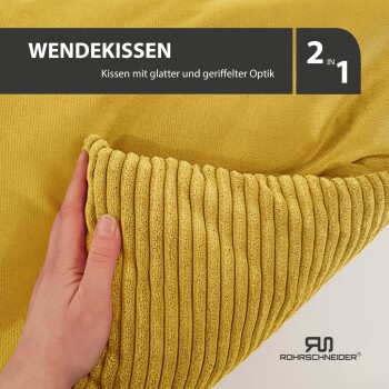 Gelbes wendbares Kissen mit glatter und gerippter Textur, beschriftet mit "WENDEKISSEN" und "2 IN 1," gehalten von einer Hand.