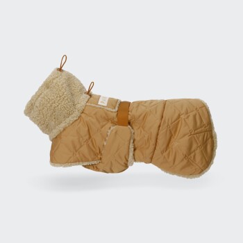 Hellbrauner gesteppter Hundemantel mit cremefarbener Sherpa-Fütterung, verstellbarem Bauchriemen und kleinem Etikett mit der Aufschrift 'PAW'.
