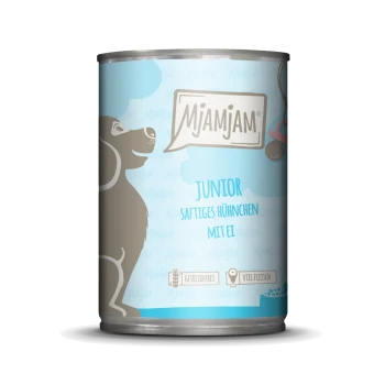 Blik hondenvoer van Mjamjam gelabeld 'Junior Saftiges Hühnchen mit Ei,' met een cartoonhond en claims dat het graanvrij en rijk aan vlees is.
