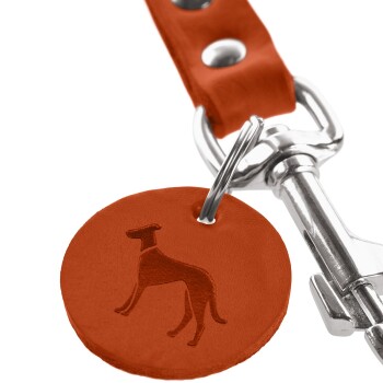 Nahaufnahme eines roten Leder-Hundemarkenanhängers mit einer geprägten Silhouette eines Hundes, der an einem silbernen Metallclip befestigt ist.