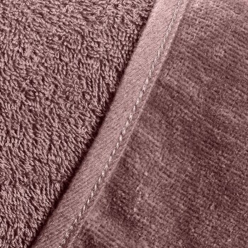 Nahaufnahme einer weichen, strukturierten Haustierdecke in einem gedämpften Rosaton, mit einer plüschigen Seite und einer glatten Seite mit sichtbaren Nähten.