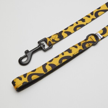 Eine lebendige gelbe Hundeleine mit einem schwarzen Leopardenmuster, mit einem stabilen schwarzen Clip und einer Schlaufe für einfaches Handling.