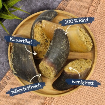 Holzschale mit gefüllten Rinderhufen als Hundekauartikeln mit Etiketten: Kauartikel, nährstoffreich, 100% Rind, wenig Fett