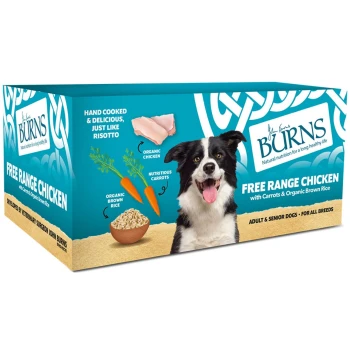 A happy black and white dog next to a box of Burns Free Range Chicken dog food, featuring carrots and organic brown rice.
