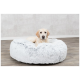 Ein gemütliches, flauschiges graues Hundebett mit einem hellen Hund, der darauf ruht, vor einem neutralen Hintergrund.