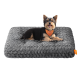 Kleiner schwarz-brauner Hund trägt ein orangefarbenes Feandrea-Halstuch und liegt auf einem strukturierten grauen Haustierbett mit orangefarbenem Feandrea-Label.