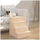 Ein Mops, der auf einem hellen Sofa mit dekorativen Kissen ruht, neben einer hölzernen Haustiertreppe, die zum Sofa führt.