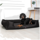 Ein grauer Weimaraner-Hund liegt auf einem braunen Haustierbett in einem modernen Wohnzimmer mit einem braunen Sofa und einem Couchtisch im Hintergrund.