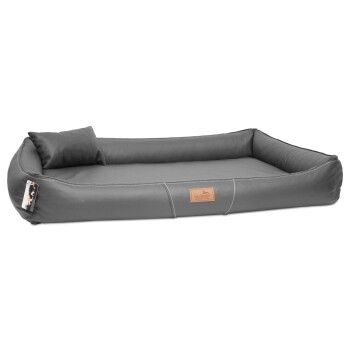 Graues Haustierbett mit gepolsterter Kante und einem kleinen Kissen, mit einer lederähnlichen Textur und einem Markenetikett.