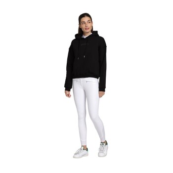 Eine Person in einem schwarzen Hoodie und weißen Leggings steht in einer entspannten Pose und zeigt ein lässiges Outfit mit weißen Turnschuhen.